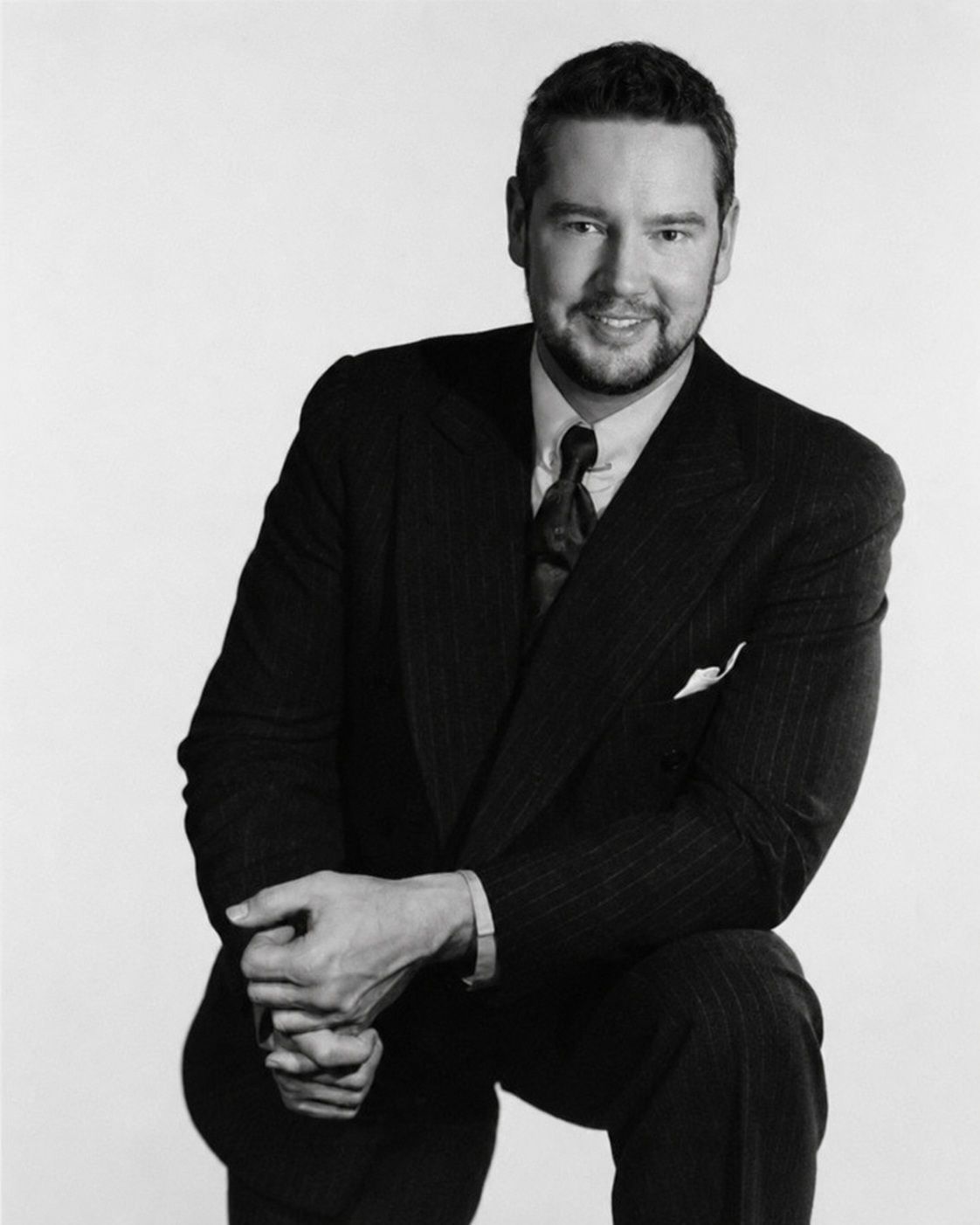 Franck Brunet en costume, portrait de studio en noir et blanc.